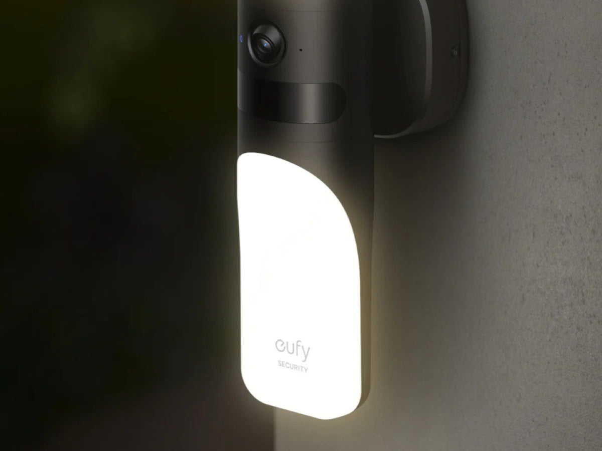 Eufy S100 zwarte wandlamp met ingebouwde 2K beveiligingscamera en heldere verlichting gemonteerd aan een buitenmuur.